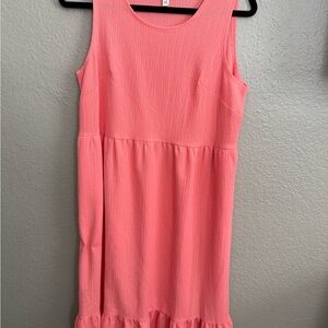 Women pull on dress. Vibrant color like a melon pinkish